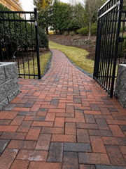 Brick paver walkway through a backyard gate in Hampton Roads